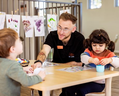 Early learning educator engaging toddlers in a hands-on classroom activity.